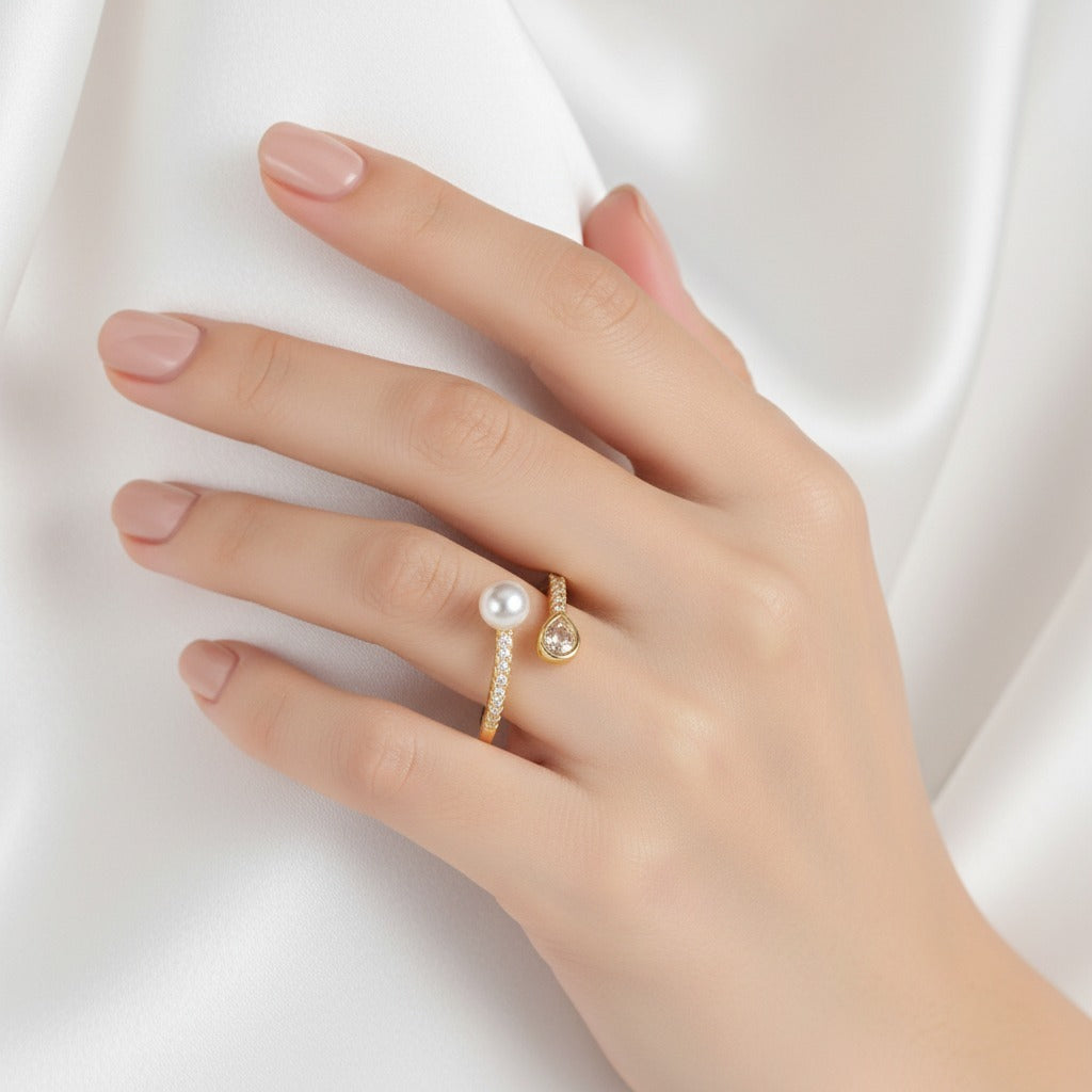 Hand wearing a pearl ring on a white background