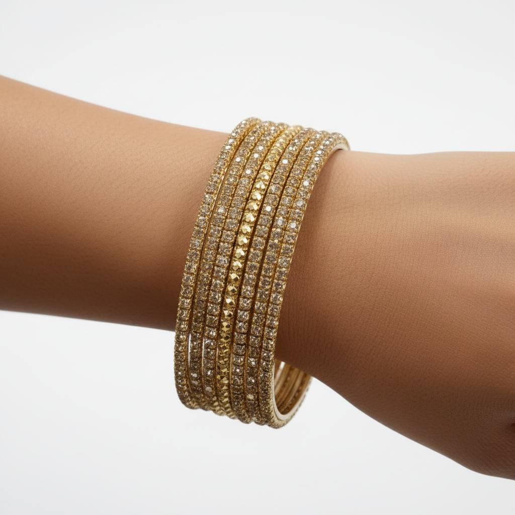 Gold diamond-cut bangles on model's wrist close-up